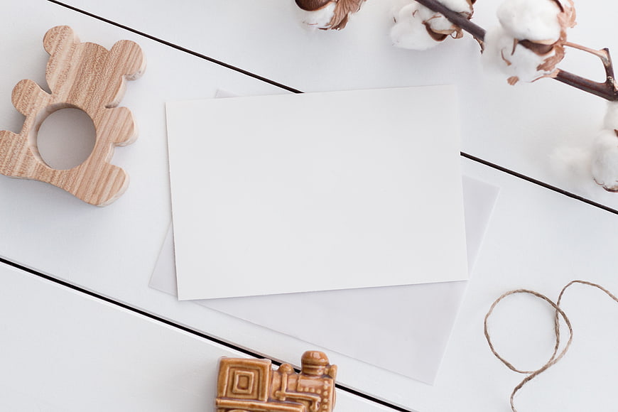 Minimalist flat lay with blank card, wooden toys, and cotton