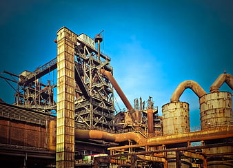 Rusty industrial steel mill architecture against blue sky
