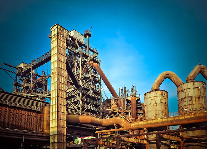 Rusty industrial steel mill architecture against blue sky