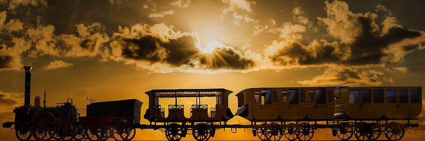 Vintage steam train silhouette against dramatic golden sunset sky