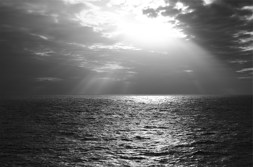 Dramatic Black and White Ocean with Sunbeams Through Clouds
