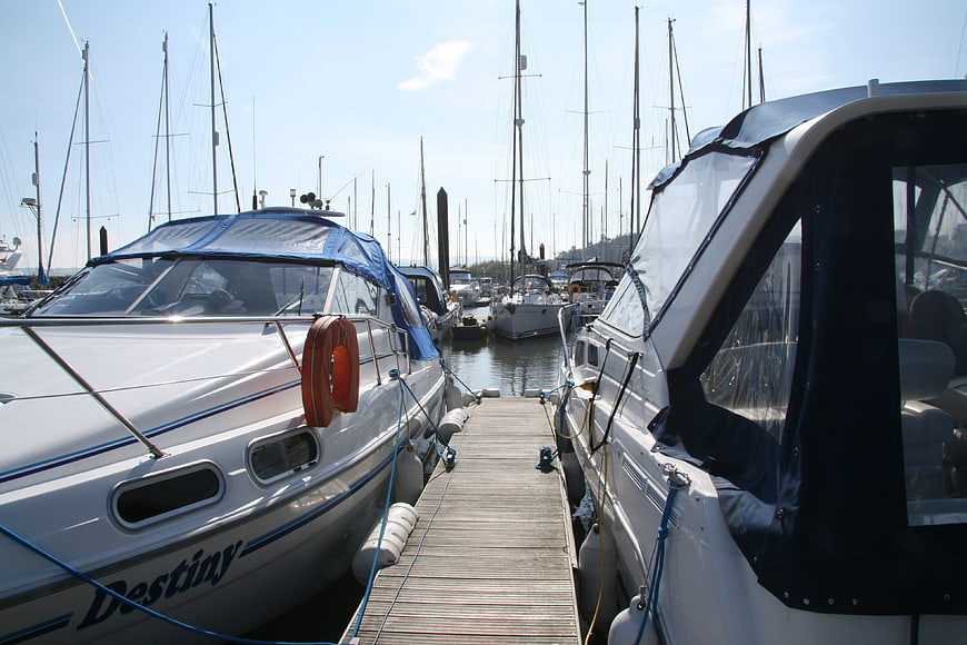 White boats docked at marina with wooden jetty