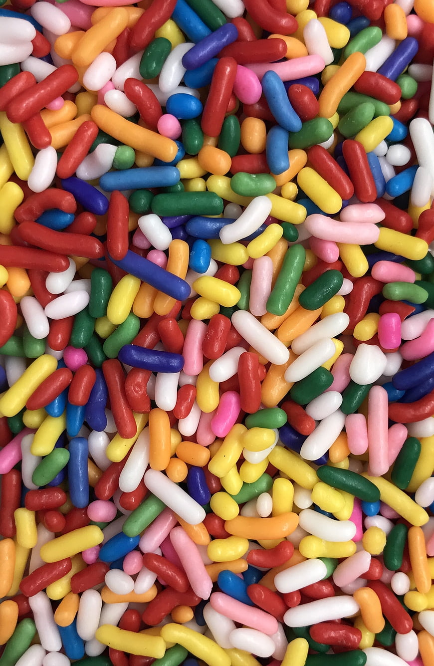 Close-up of colorful rainbow sprinkles on a white background