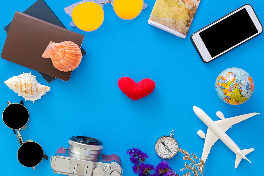 Summer Travel Flat Lay with Camera, Passport, and Seashells on Blue Background