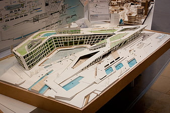 Architectural model of modern building with green roof and pools