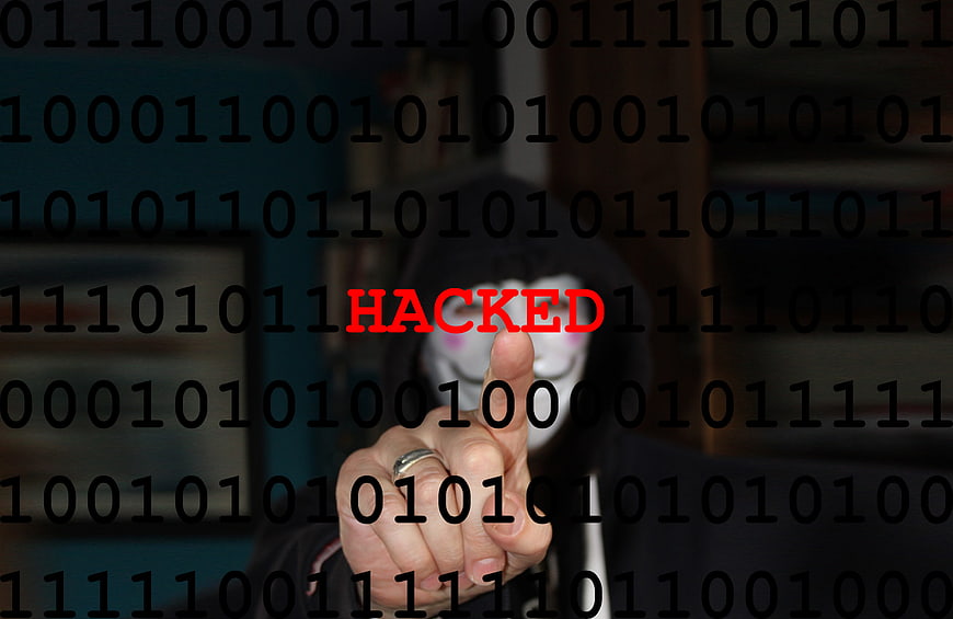 Hacker in Hoodie Pointing at Hacked Text Overlay