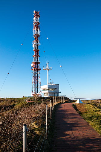 Red and white radio mast on Helgoland island with blue sky