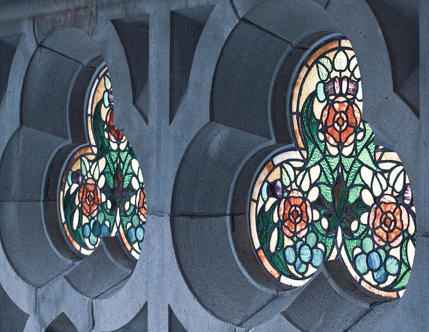 Stained glass floral window detail in stone architecture