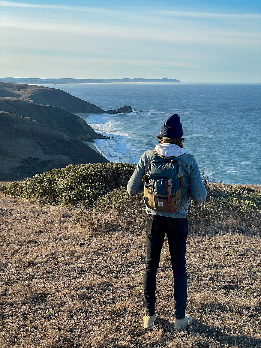 Hiker with Backpack Overlooking Scenic Coastal Ocean View