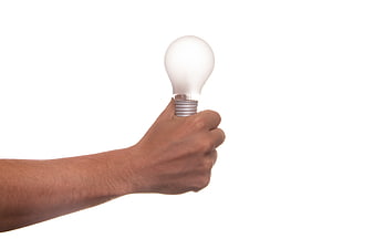 Hand holding glowing light bulb on white background