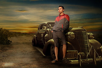 Man in Nike Jacket Leaning on Vintage Car at Sunset