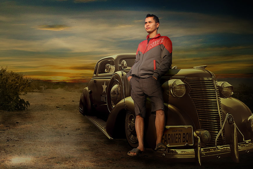 Man in Nike Jacket Leaning on Vintage Car at Sunset