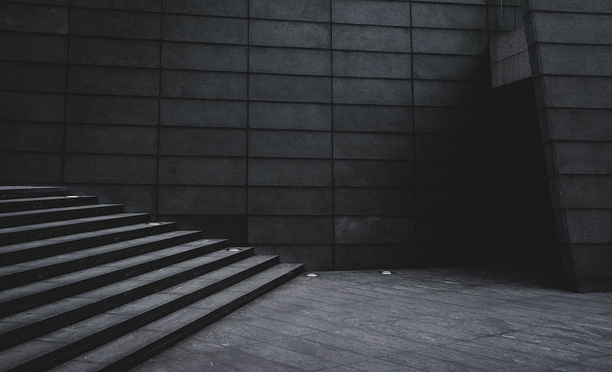 Dark minimalist stone staircase and textured wall architecture