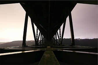 Low angle view of steel bridge truss structure at dusk