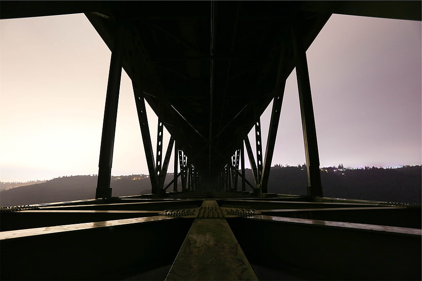 Low angle view of steel bridge truss structure at dusk