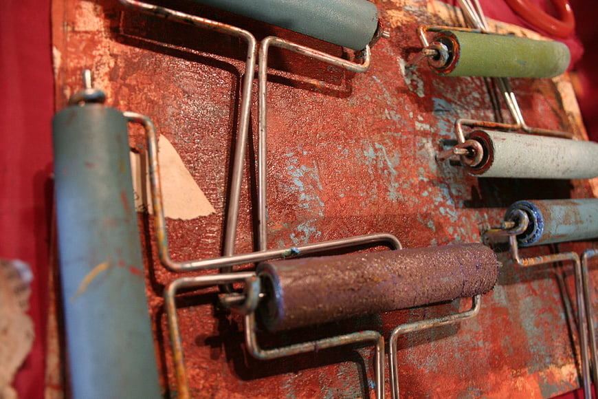 Vintage Paint Rollers on Rusty Metal Surface