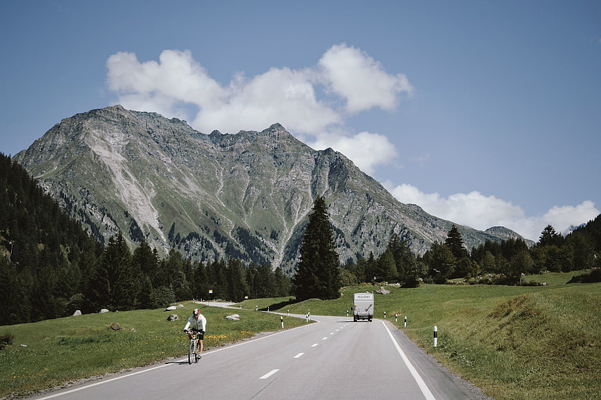 Cyclist and camper van on winding mountain road
