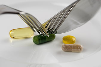 Pills on a plate with fork and knife