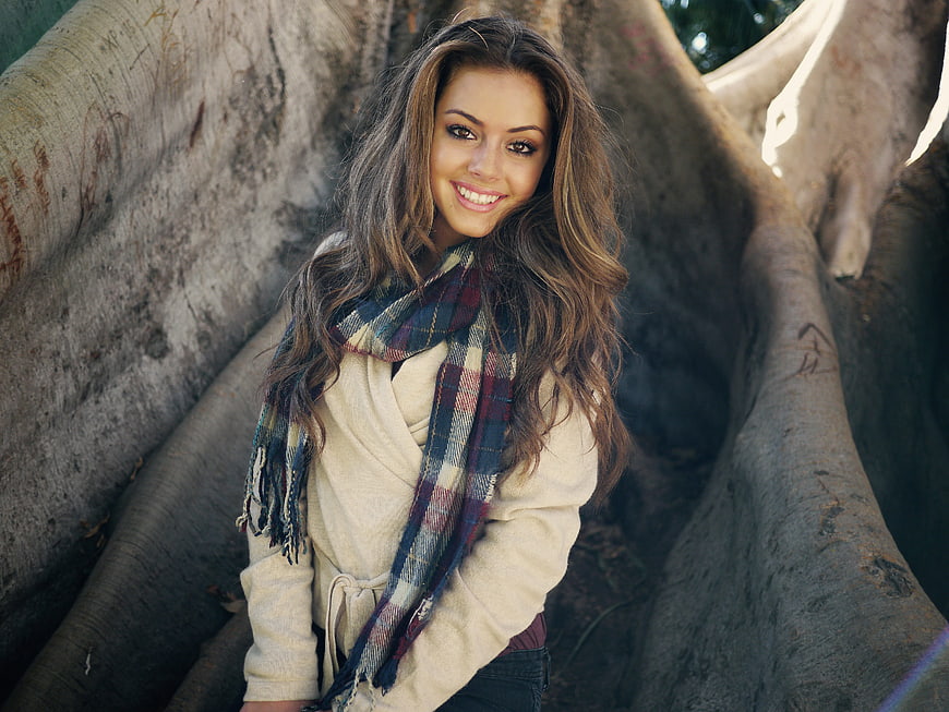 Smiling Brunette Woman in Scarf Sitting by Tree Roots
