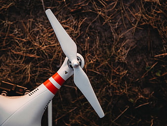Close-up of white drone propeller on dry grass