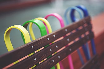Colorful metal loops on wooden park bench detail