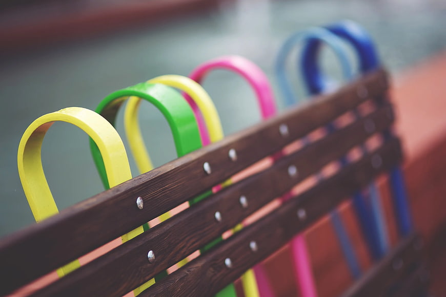 Colorful metal loops on wooden park bench detail