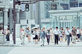 Crowd of pedestrians crossing street in modern Japanese city