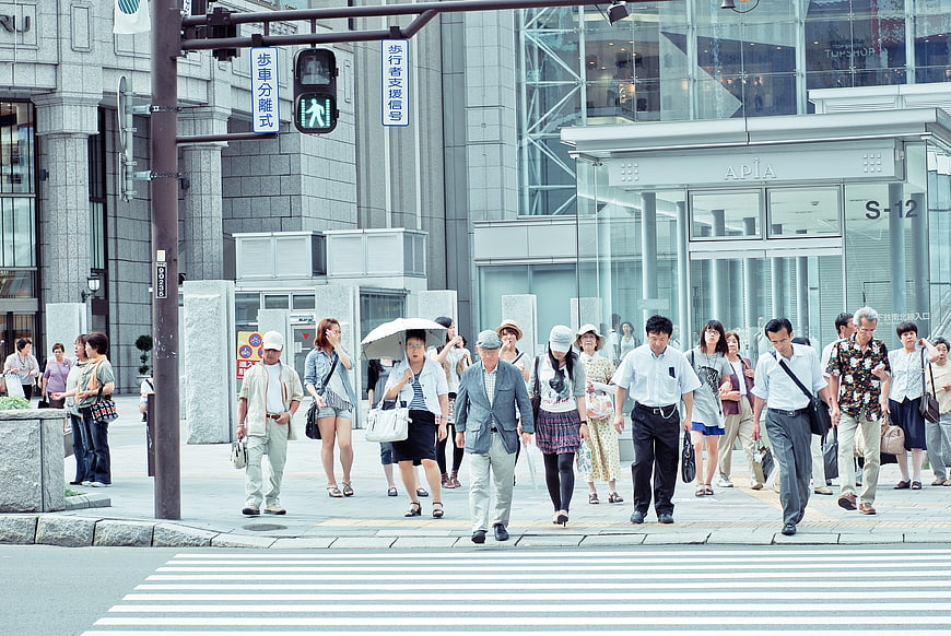 Crowd of pedestrians crossing street in modern Japanese city