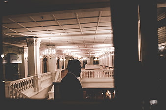 Silhouette of Man in Grand Hallway with Chandeliers