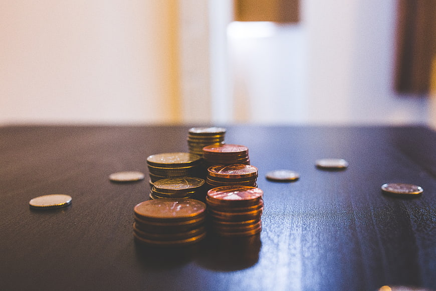 Stacks of Euro coins on a dark wooden table