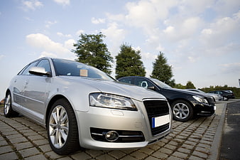 Silver Audi Sedan Parked In Front Of Black Car