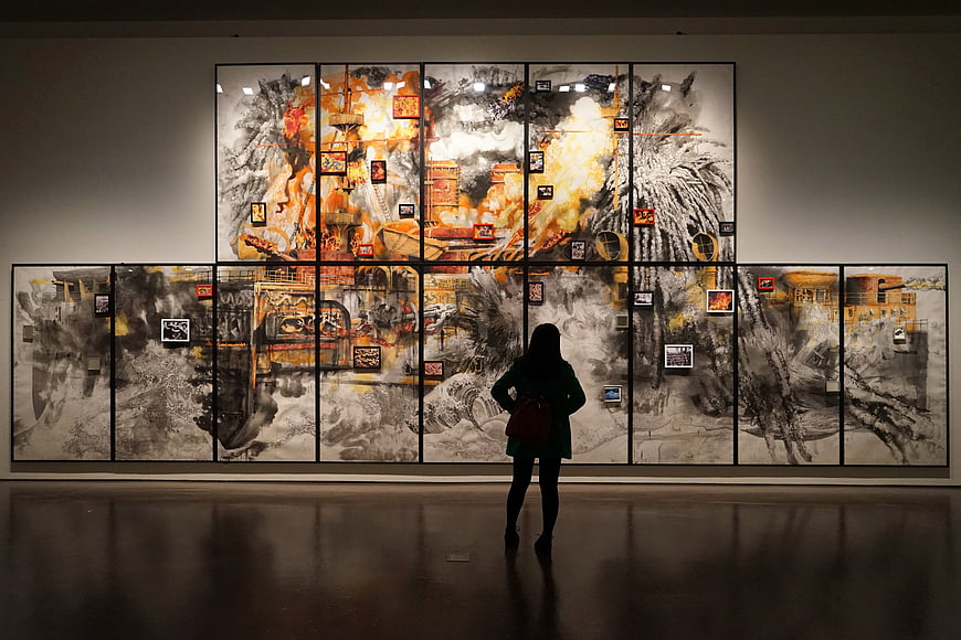 Woman viewing large abstract art installation in museum gallery