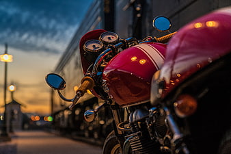 Close-up of red cafe racer motorcycle at dusk