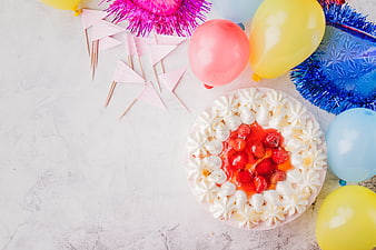 Top view birthday cake with strawberries and colorful balloons