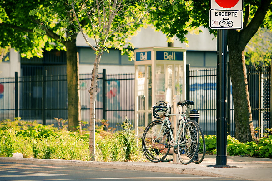 Bicycle parked on sidewalk near vintage Bell phone booth
