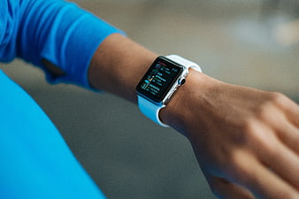 Close-up of person wearing white smartwatch with blue shirt