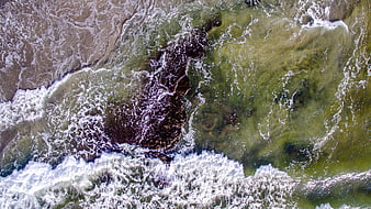 Aerial View of Turquoise Ocean Waves Crashing on Rocky Coast