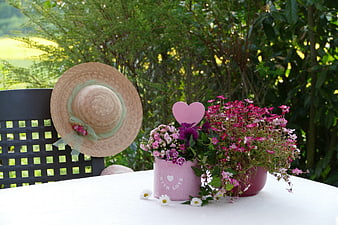 Pink Flower Arrangement with Straw Hat on White Table