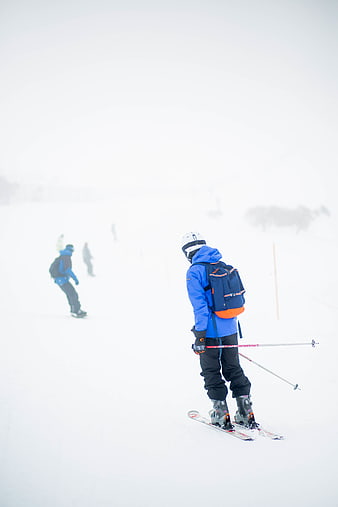Skier in Blue Jacket on Snowy Slope
