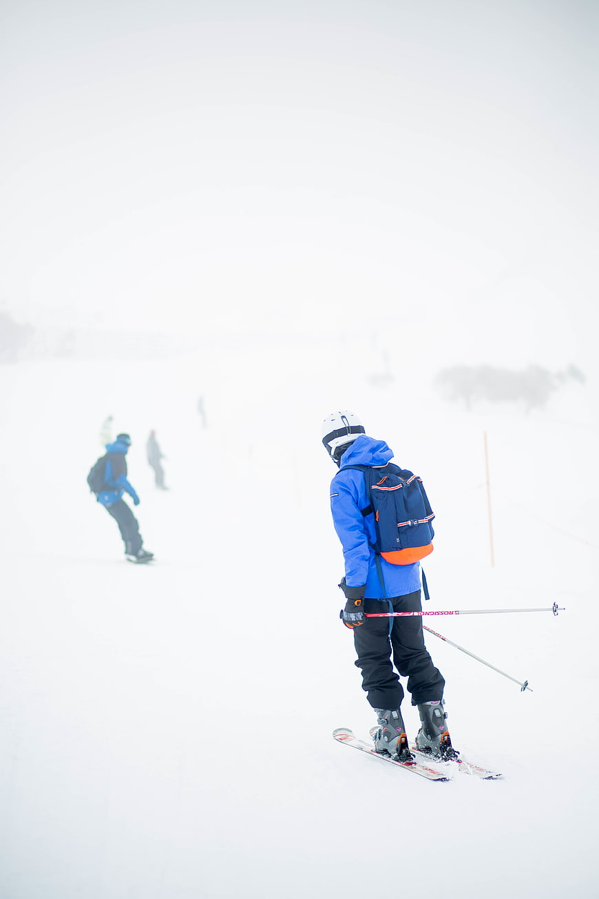 Skier in Blue Jacket on Snowy Slope
