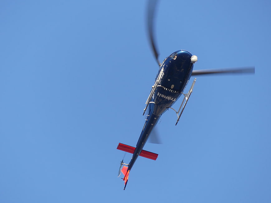 Blue Helicopter Flying Against Clear Blue Sky