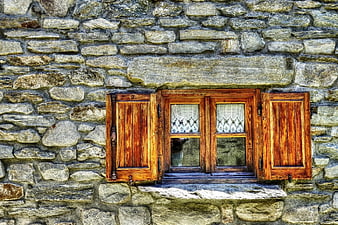 Rustic wooden window with shutters on old stone wall