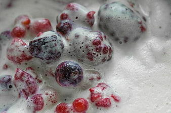 Close-up of mixed berries in frothy white cream
