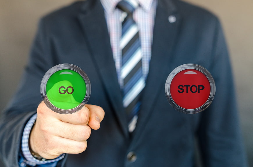 Businessman Pressing Green Go Button With Stop Option