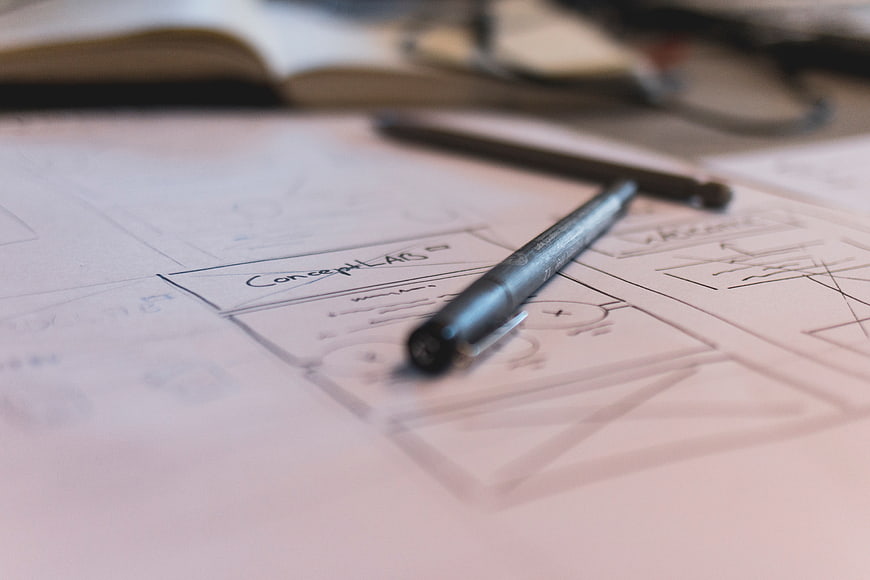 Hand-drawn mobile app wireframe sketches with pen on paper