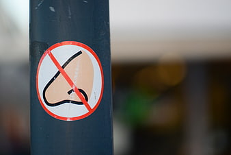 No nose picking sign on blue pole