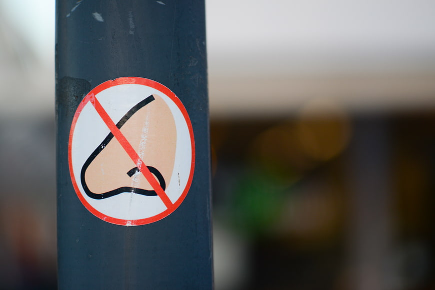 No nose picking sign on blue pole