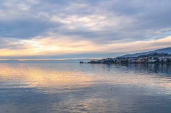 Serene Lake Geneva Sunset With Montreux Townscape And Cloudy Sky