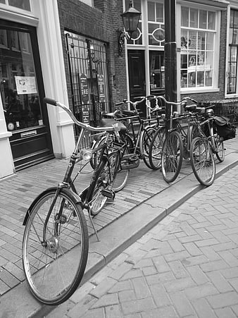 Black and white bicycles parked on cobblestone street in Amsterdam