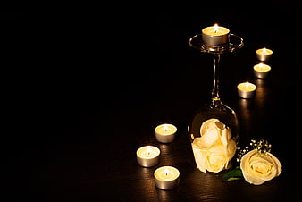Romantic White Roses and Candles in Wine Glass on Dark Background